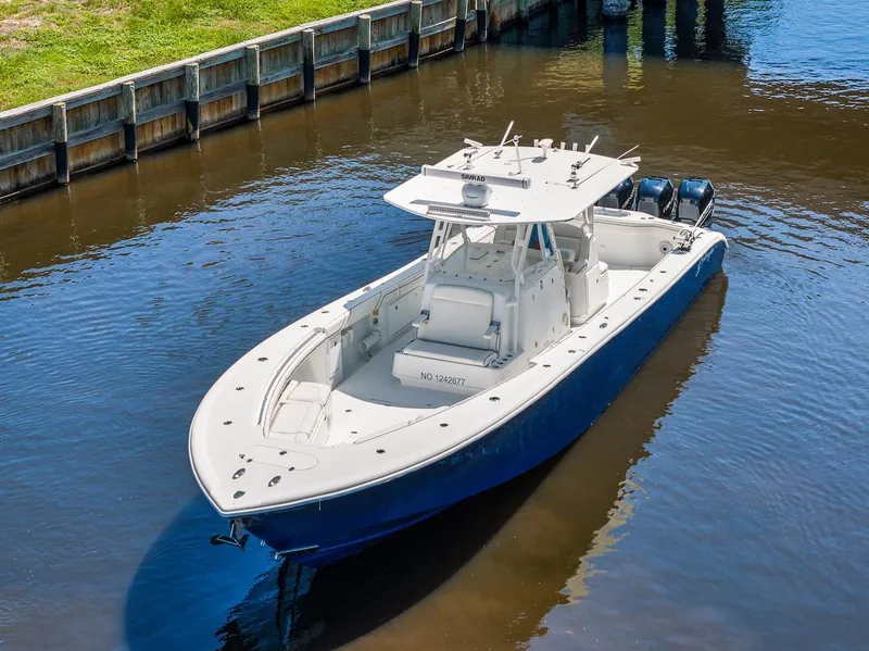 Slide: The Image of 2015 Yellowfin 39 boat navigating a calm canal under a clear blue sky. - 5