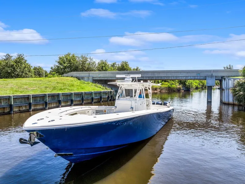 Slide: The Image of 2015 Yellowfin 39 boat on calm water near a wooden dock. - 6