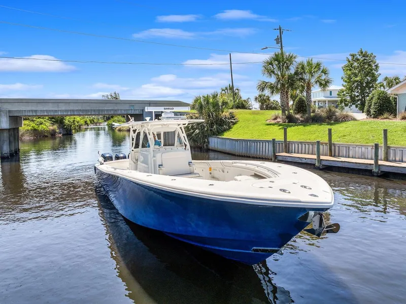 Slide: The Image of 2015 Yellowfin 39 boat cruising on a calm river under a blue sky. - 7