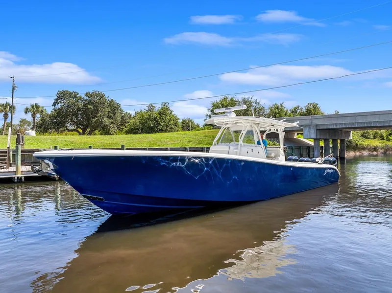 Slide: The Image of 2015 Yellowfin 39 boat on calm water near a grassy shoreline. - 9
