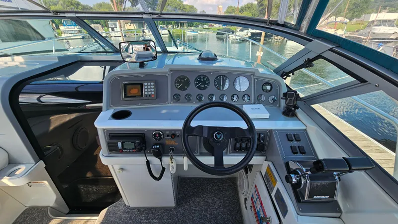 Slide: The Image of 1994 Formula 31 PC boat cockpit with steering wheel, gauges, and control panel at marina. - 10