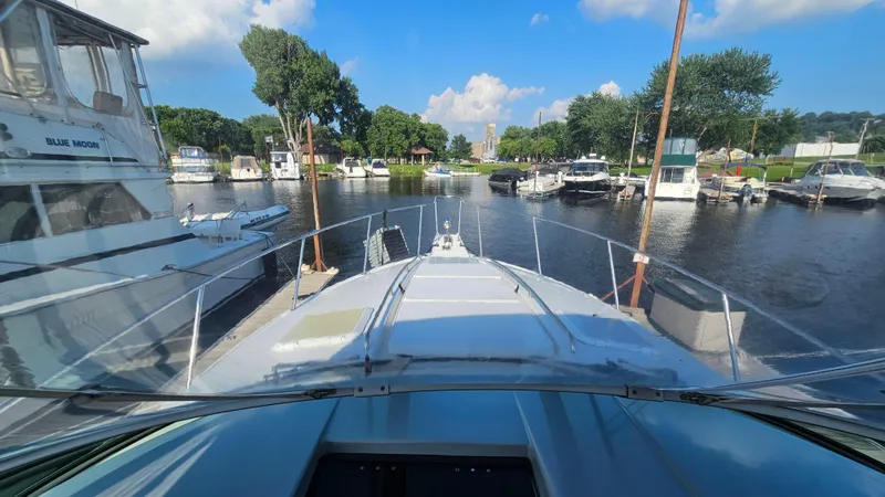 Slide: The Image of 1994 Formula 31 PC boat docked in a marina with clear skies and surrounding boats. - 11