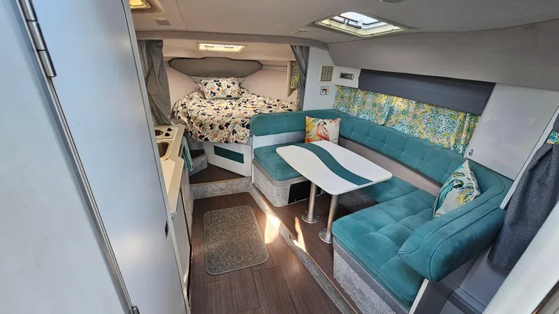 Slide: The Image of 1994 Formula 31 PC interior with teal seating, floral bedding, and compact kitchen area. - 12