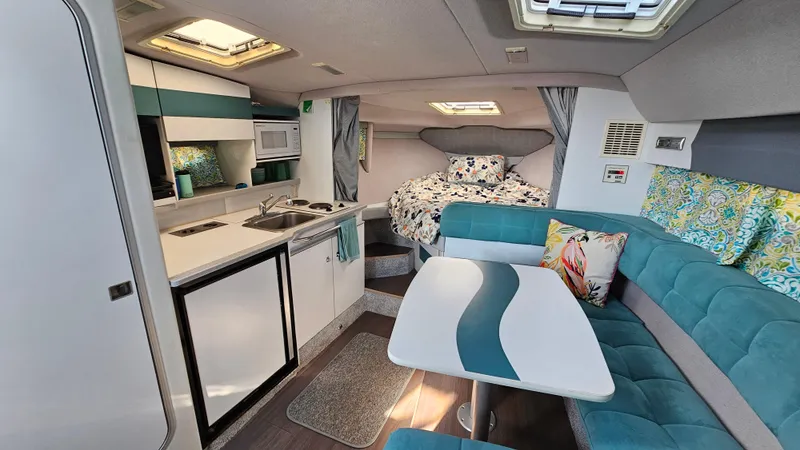 Slide: The Image of 1994 Formula 31 PC boat interior with kitchen, dining area, and cozy sleeping space. - 13