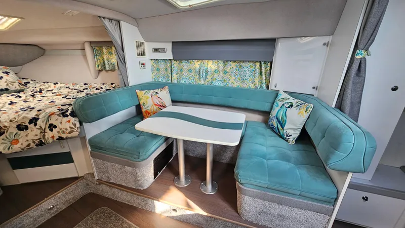 Slide: The Image of 1994 Formula 31 PC interior with teal seating, floral bedding, and decorative pillows. - 14