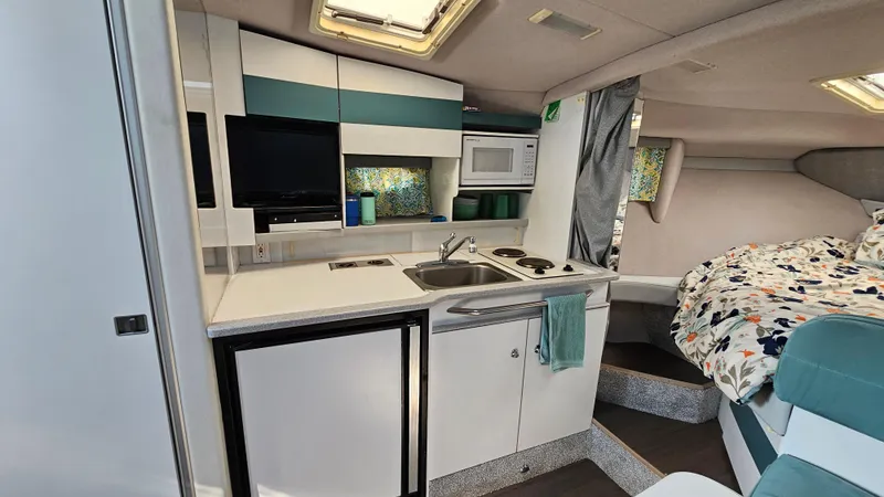 Slide: The Image of 1994 Formula 31 PC interior with kitchenette, microwave, and cozy sleeping area. - 16