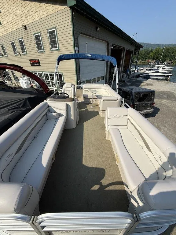 Slide: The Image of 2015 Bennington 21 SLX pontoon boat with beige seating, docked near a marina. - 12