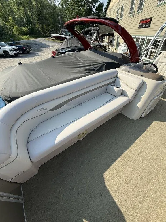 Slide: The Image of 2015 Bennington 21 SLX pontoon boat with white seating, docked near a building. - 13