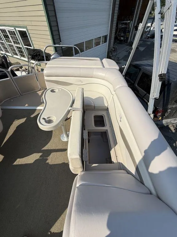 Slide: The Image of 2015 Bennington 21 SLX boat interior with beige seating and a small table. - 16
