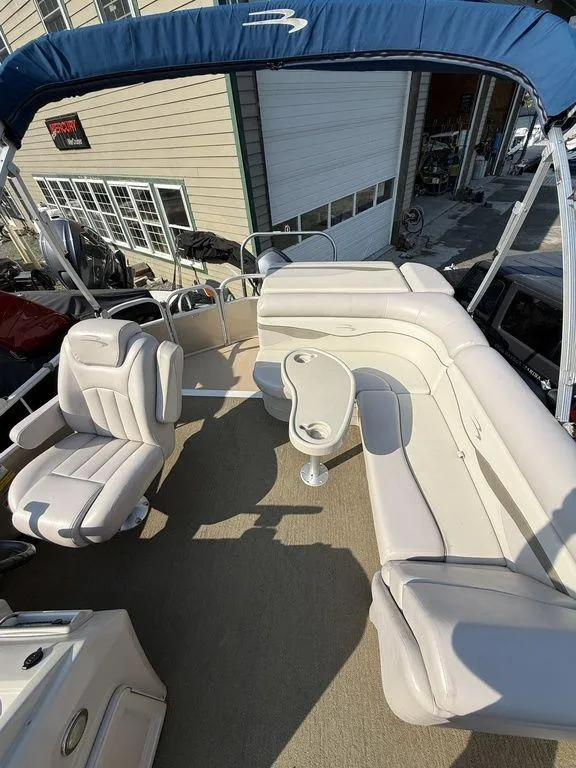 Slide: The Image of 2015 Bennington 21 SLX pontoon boat interior with beige seating and blue canopy. - 17