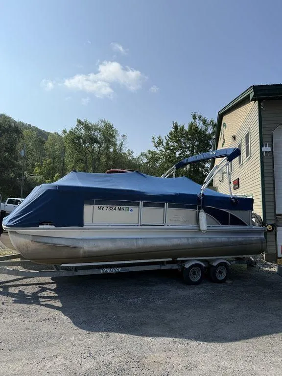 Slide: The Image of 2015 Bennington 21 SLX pontoon boat with blue cover on trailer. - 2