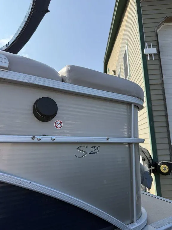 Slide: The Image of 2015 Bennington 21 SLX pontoon boat near a building, showcasing sleek design. - 5
