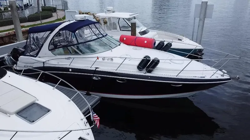 Slide: The Image of 2006 Four Winns 348 Vista boat docked at marina, featuring sleek design and canopy. - 2