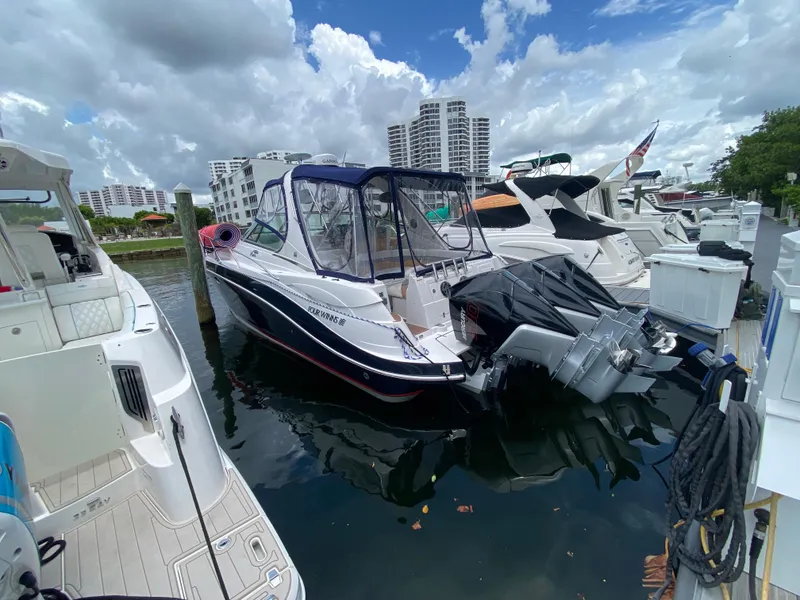 Slide: The Image of 2006 Four Winns 348 Vista boat docked at marina, surrounded by other vessels, under cloudy sky. - 24