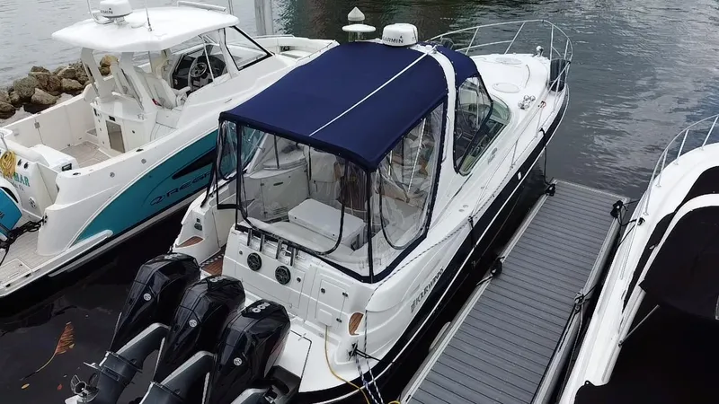 Slide: The Image of 2006 Four Winns 348 Vista boat docked with blue canopy and triple outboard motors. - 30