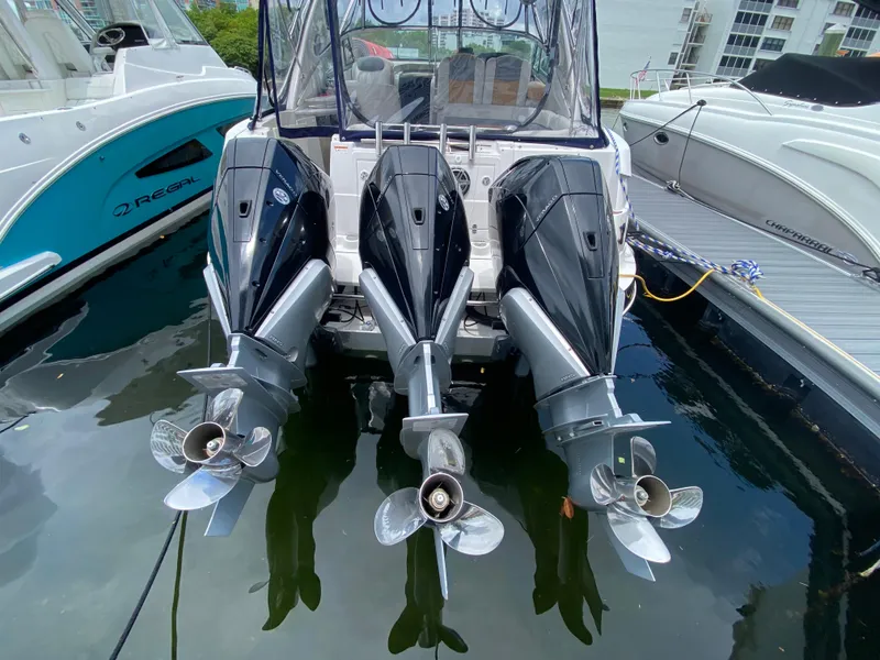 Slide: The Image of Three powerful outboard motors on a 2006 Four Winns 348 Vista boat docked in a marina. - 31