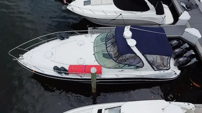 Slide: The Image of 2006 Four Winns 348 Vista boat docked, aerial view, with blue canopy and red cushion. - 5