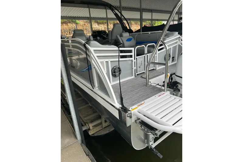 Slide: The Image of 2025 JC NEPTOON 27TT SPORT pontoon boat docked under a covered area. - 22