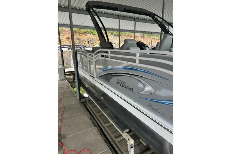 Slide: The Image of 2025 JC NEPTOON 27TT SPORT pontoon boat docked under a covered area. - 23