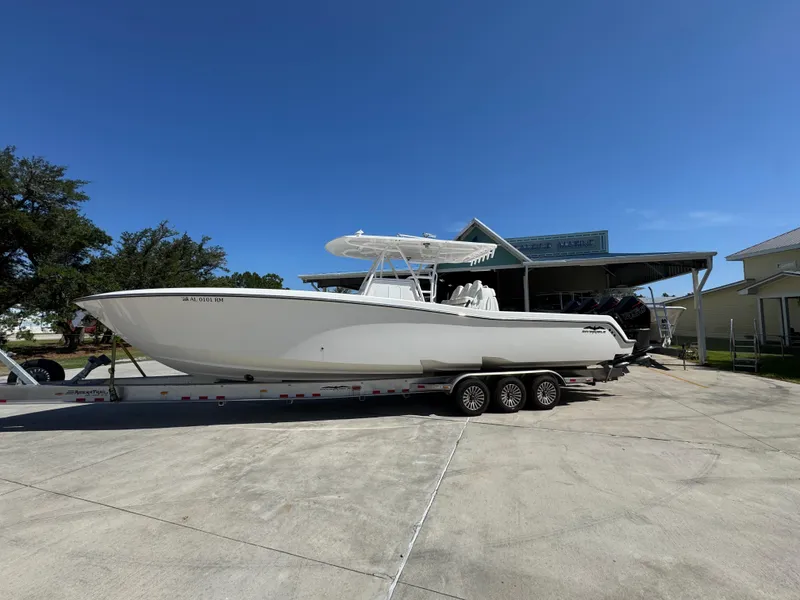 The Image of 2020 Invincible 39 Open Fisherman boat on trailer, parked outdoors under clear blue sky. - 1