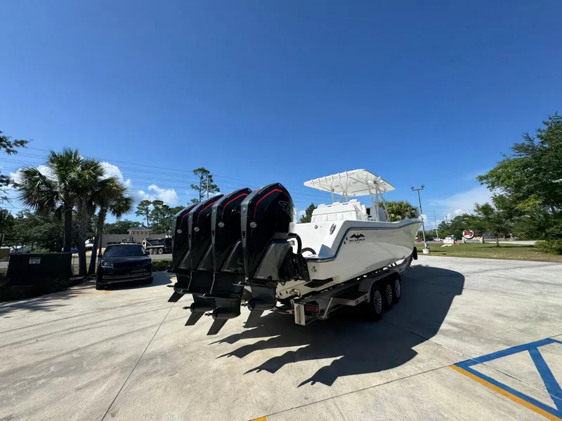 Slide: The Image of 2020 Invincible 39 Open Fisherman boat with multiple engines on a trailer under clear blue sky. - 17