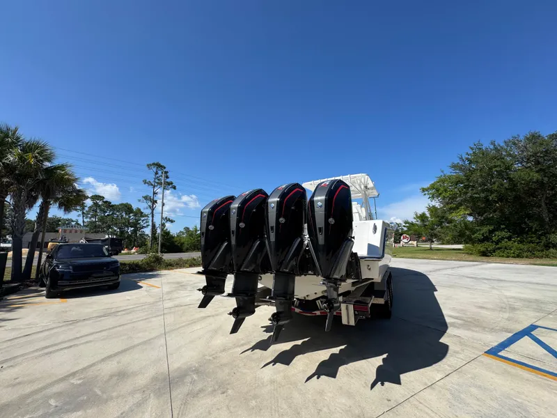 Slide: The Image of 2020 Invincible 39 Open Fisherman boat with four powerful outboard engines in a sunny parking lot. - 18