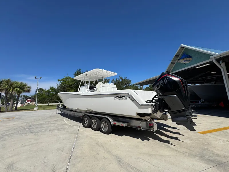 Slide: The Image of 2020 Invincible 39 Open Fisherman boat on trailer, parked outdoors under clear blue sky. - 23