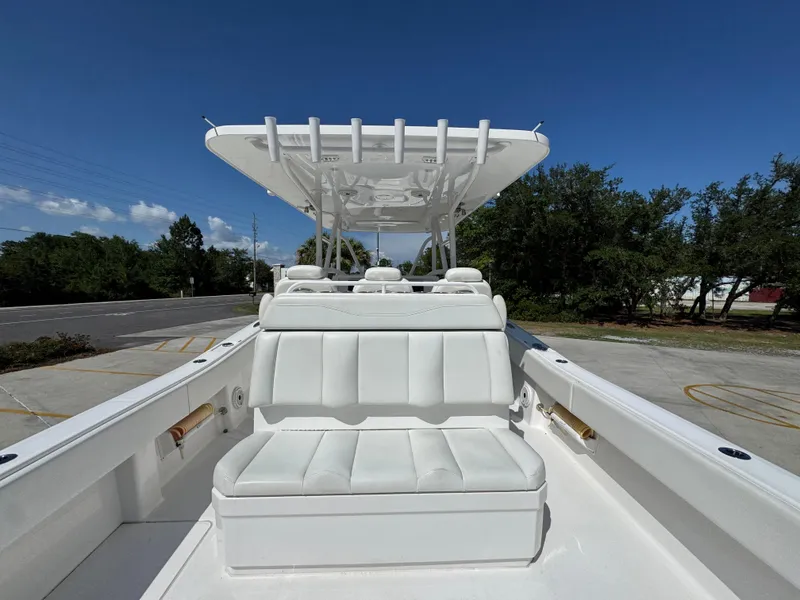 Slide: The Image of Invincible 39 Open Fisherman 2020 boat with white seating and canopy under clear blue sky. - 42