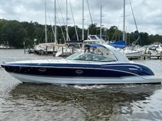 The Image of 2012 Formula 350 Sun Sport boat on water, surrounded by sailboats and trees. - 0