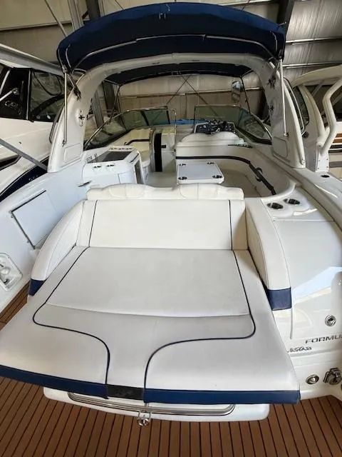 Slide: The Image of 2012 Formula 350 Sun Sport boat with spacious seating and sleek design in a marina setting. - 19