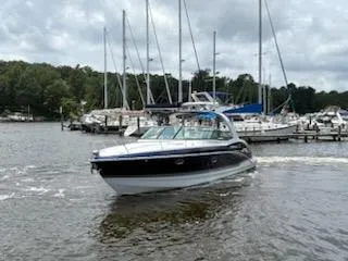 Slide: The Image of 2012 Formula 350 Sun Sport boat cruising near marina with sailboats in background. - 38
