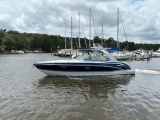 Slide: The Image of 2012 Formula 350 Sun Sport boat cruising on a lake with sailboats in the background. - 8