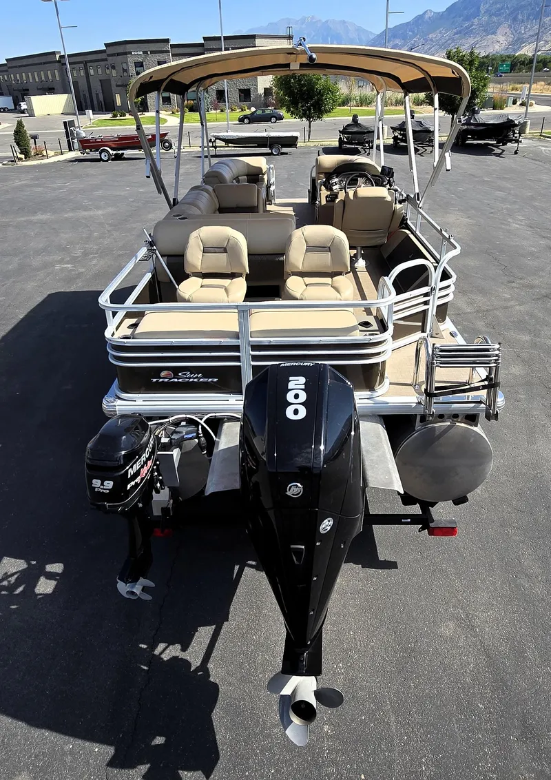 Slide: The Image of 2023 Sun Tracker SportFish 22 XP3 pontoon boat with dual Mercury engines, parked outdoors. - 11