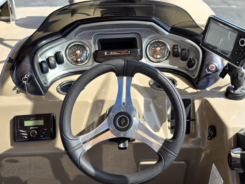 Slide: The Image of 2023 Sun Tracker SportFish 22 XP3 dashboard with steering wheel and control panel. - 23