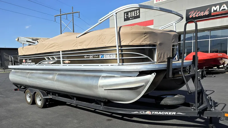 Slide: The Image of 2023 Sun Tracker SportFish 22 XP3 pontoon boat on trailer, parked outside dealership. - 26