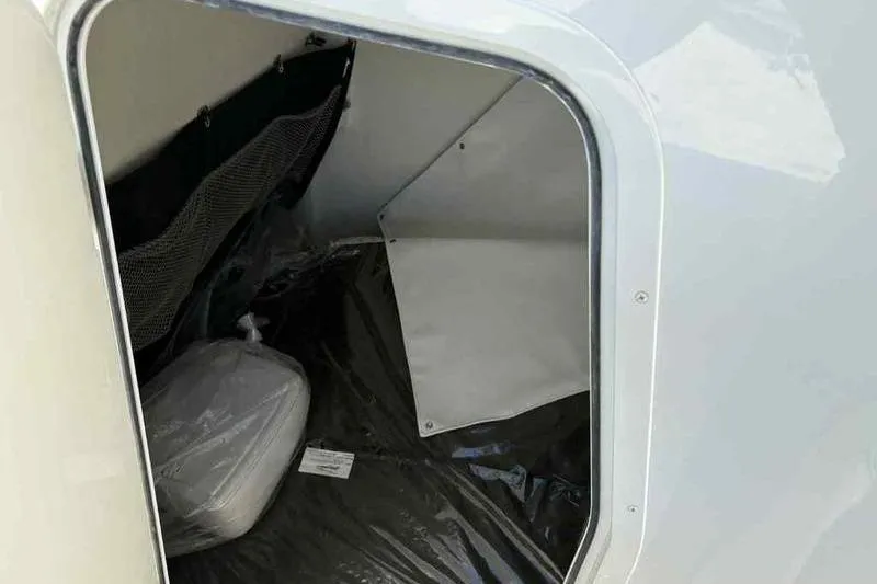 Slide: The Image of Storage compartment of 2026 Parker 2900 CC boat, featuring interior netting and seating. - 16