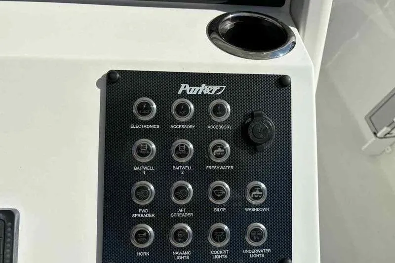Slide: The Image of Control panel of 2026 Parker 2900 CC boat with labeled switches and cup holder. - 18