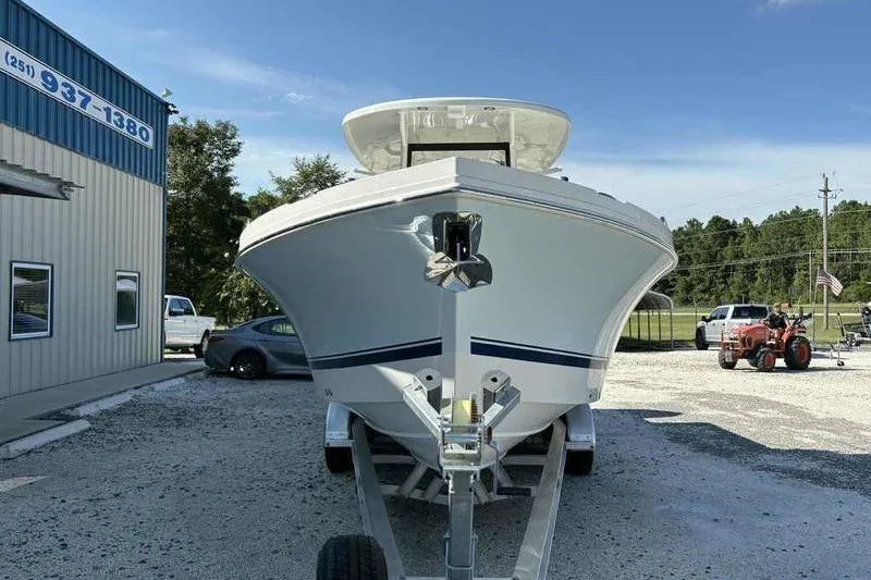Slide: The Image of 2026 Parker 2900 CC boat on trailer, parked outside a building under clear blue sky. - 2