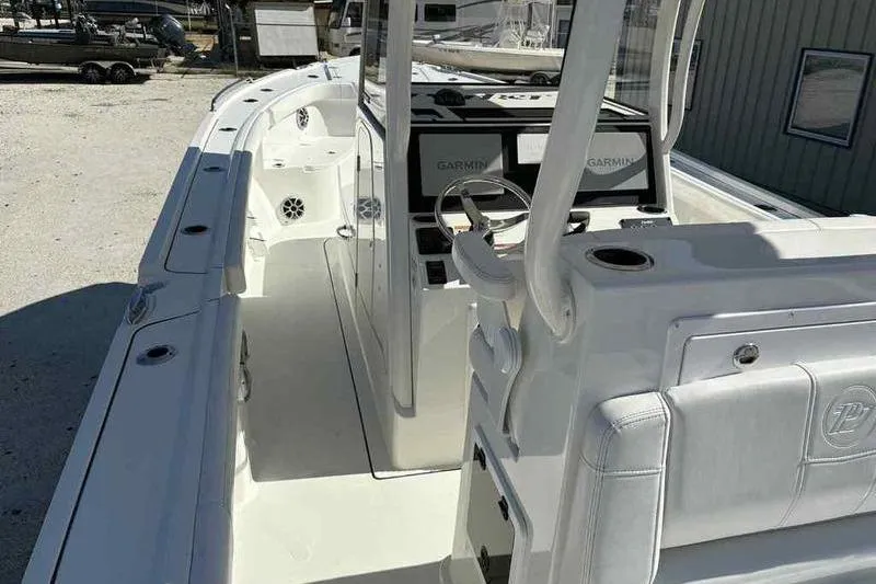 Slide: The Image of 2026 Parker 2900 CC boat interior with Garmin navigation system, white seating, and steering console. - 9
