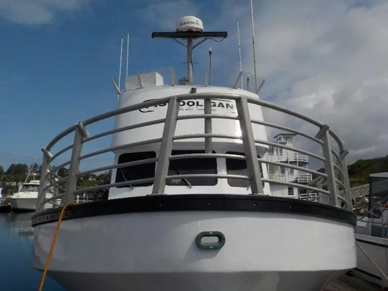 Slide: The Image of Front view of a 1974 custom passenger vessel docked at a marina. - 12
