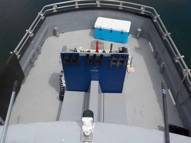 Slide: The Image of Bow of a 1974 custom passenger vessel with a blue cooler and railing. - 13