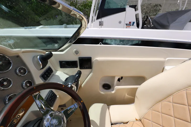 Slide: The Image of 2020 Chris-Craft 30 Launch boat interior with steering wheel and dashboard controls. - 17