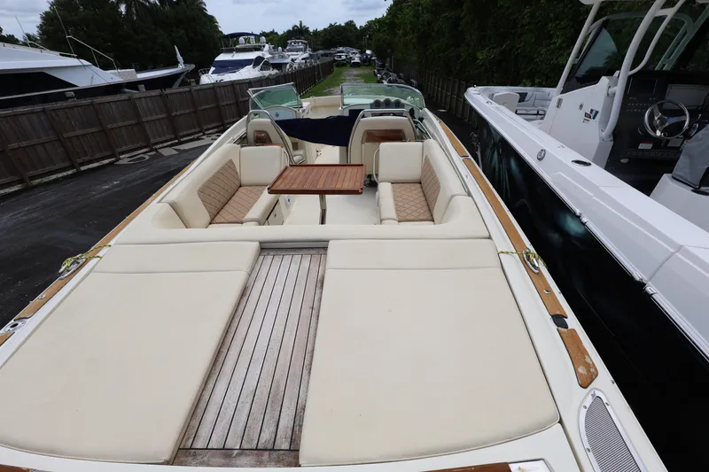 Slide: The Image of 2020 Chris-Craft 30 Launch boat with spacious seating and wooden deck, docked beside other vessels. - 4