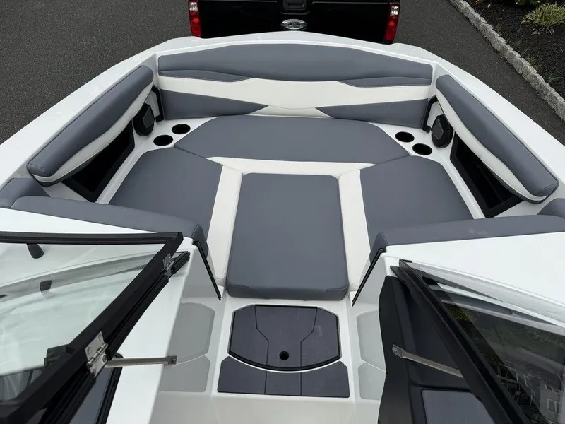 Slide: The Image of 2026 Axis A225 boat interior with gray and white seating, cup holders, and open windshield. - 15