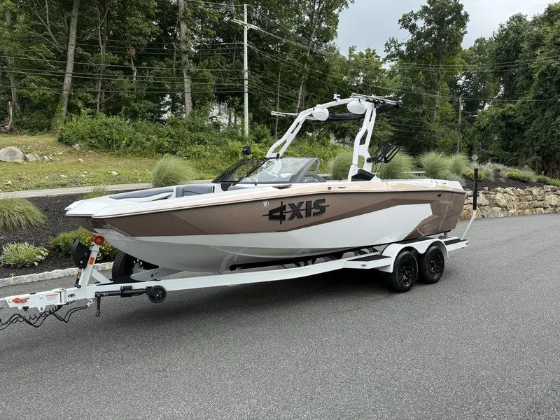 Slide: The Image of 2026 Axis A225 boat on trailer, parked on a road with lush greenery background. - 7