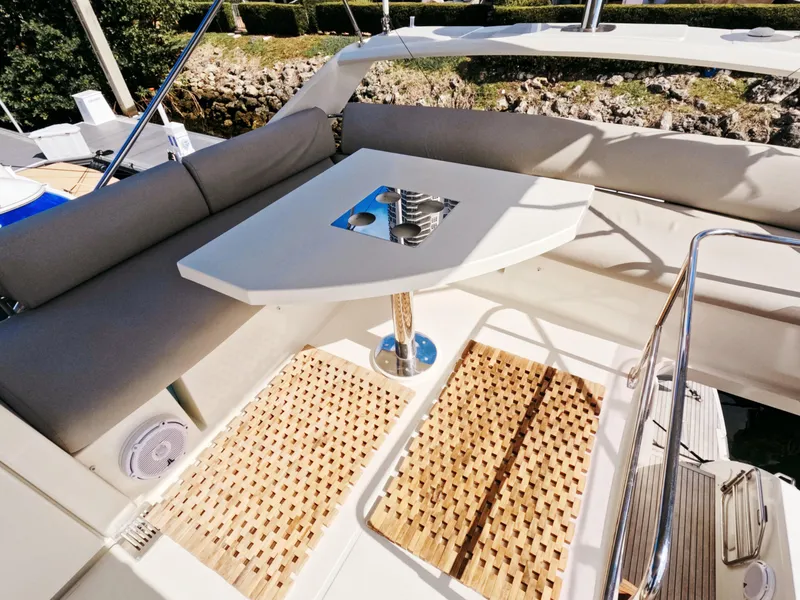 Slide: The Image of Prestige 460 yacht 2020 model, outdoor seating area with table and cushions. - 13