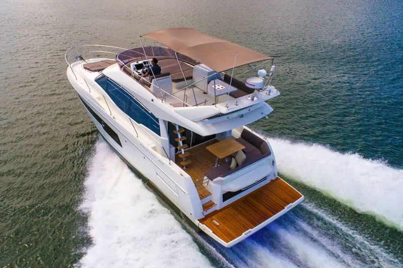 Slide: The Image of Luxury 2020 Prestige 460 yacht cruising on open water, showcasing sleek design and spacious deck. - 4