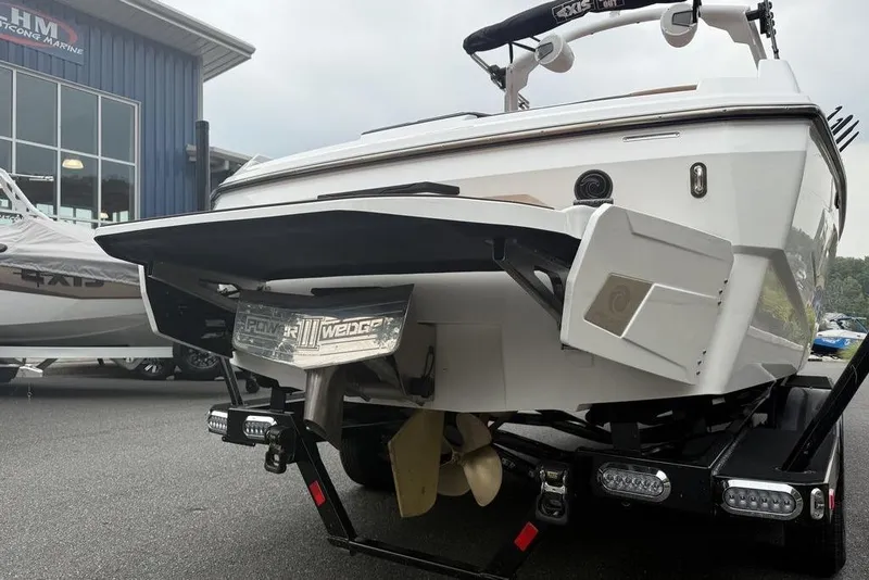Slide: The Image of 2026 Axis A225 boat rear view with Power Wedge III, parked at a marine dealership. - 7