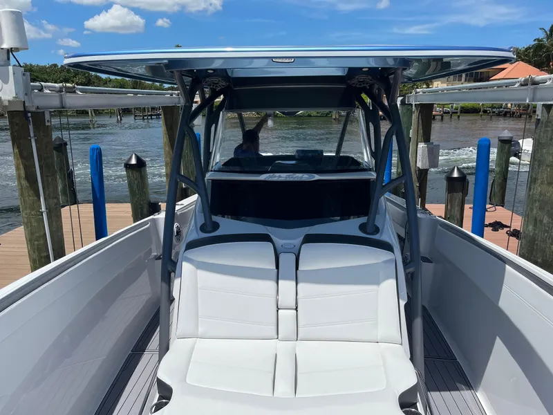 Slide: The Image of 2023 Nor-Tech 340 Sport Open Center Console boat docked by the water. - 2