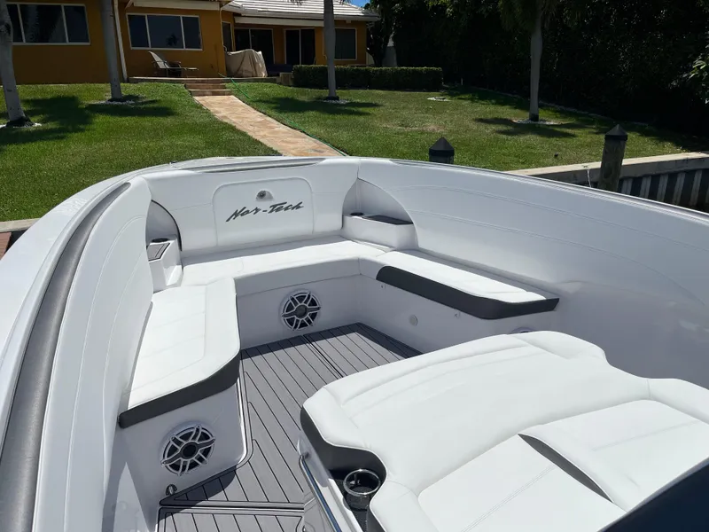 Slide: The Image of 2023 Nor-Tech 340 Sport Open Center Console boat with white seating and speakers. - 6